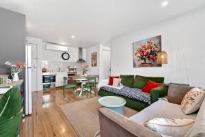 ein Wohnzimmer mit einer grünen Couch und einer Küche in der Unterkunft Fingal 1BR Sleeps 5 Apartment 28, Golf ,Beach, Hot Springs in Fingal