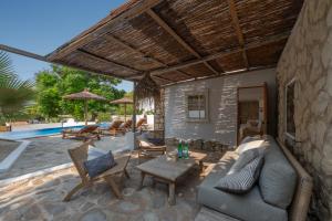 a patio with a couch and chairs and a pool at Casa Cobalto, Sea view, Mediterranean, Sea 700meters, 4 Bedrooms in Benissa
