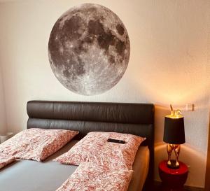 a bedroom with a moon mural on the wall at Schlosswache21 in Zerbst