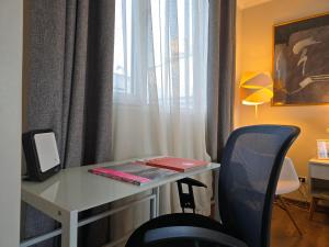 a desk with a laptop and a chair in a room at Santiago Centro Bellas Artes Lastarria in Santiago