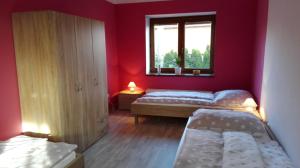 ein rotes Zimmer mit 2 Betten und einem Fenster in der Unterkunft Apartment Těchov in Blansko