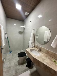 a bathroom with a sink and a toilet and a mirror at Pousada Canta Galo in Goiás