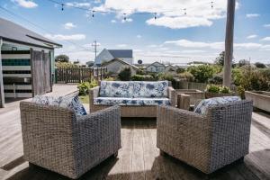 three wicker chairs and a couch on a patio at Saltwood Peterborough in Peterborough