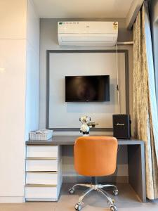 a bedroom with a desk with a television and a chair at Lux Paradise By Aurum in Noida