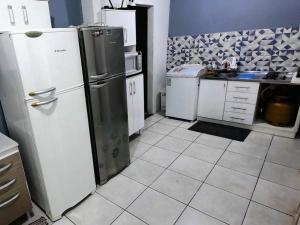 a kitchen with two refrigerators and a counter top at Quarto econômico Centro Itajai in Itajaí