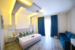 una camera da letto con un letto e un divano blu di Elysium Hotel a Dhërmi Altre 37 foto