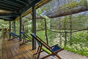 a screened in porch with chairs and a table at Lodge Apartment at Owl Creek Farm Resort in Murphy +21 photos