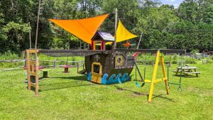a playground with a play equipment in the grass at Lodge Apartment at Owl Creek Farm Resort in Murphy