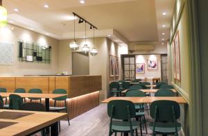 a dining room with tables and green chairs at Hotel Balfers in Montevideo