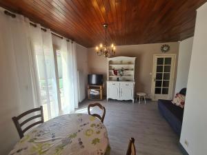 a living room with a table and a chandelier at Maison de vacances en Berry avec jardin clos, proche plage et sentiers, animaux acceptés - FR-1-591-319 in Baraize