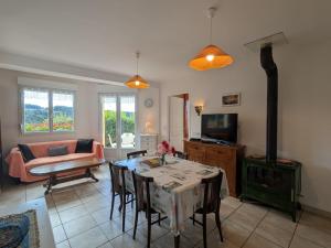 a living room with a table and a stove at Gîte à la montagne avec cheminée, wifi et joli terrain - FR-1-589-179 in Le Tholy