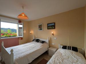 two beds in a bedroom with a window at Gîte à la montagne avec cheminée, wifi et joli terrain - FR-1-589-179 in Le Tholy