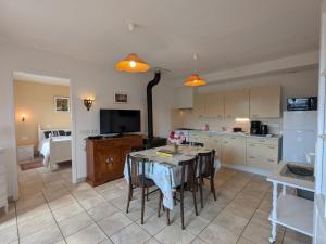 a kitchen with a table with chairs and a kitchen with at Gîte à la montagne avec cheminée, wifi et joli terrain - FR-1-589-179 in Le Tholy