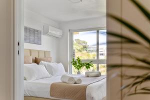 ein Schlafzimmer mit einem großen Bett mit weißen Laken und einem Fenster in der Unterkunft MBird 19 Estoril Apartments in Estoril + 171 Fotos