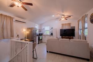 un salon avec un canapé et un ventilateur de plafond dans l'établissement Casa Sirena Belize! Sirena House, à Caye Caulker