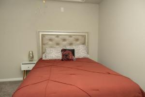 a bed with a red comforter and a pillow on it at Cozy Room with Private bath in Richmond, TX in Richmond
