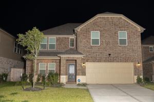 a brick house with a garage at night at Cozy Room with Private bath in Richmond, TX in Richmond