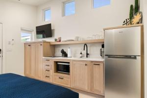 eine Küche mit Holzschränken und einem Edelstahlkühlschrank in der Unterkunft Downtown Kokopelli West 5 - Newly Remodeled Stylish Studio in Moab