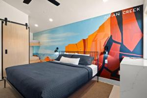 a bedroom with a bed with a painting on the wall at Downtown Kokopelli West 6 - Newly Remodeled Stylish Studio in Moab
