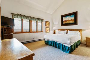a bedroom with a bed and a flat screen tv at RMR: Wind River 4 Condo in Teton Village in Teton Village +19 photos