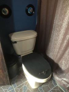 a toilet with a black seat in a bathroom at CASA QUETZALCOATl in Oaxaca City +1 photo