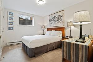a bedroom with a bed and a table with a lamp at RMR: Teodori House in Teton Village in Teton Village