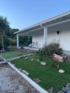 a yard with rocks on the grass in front of a house at Casa da Oliveira in Melides