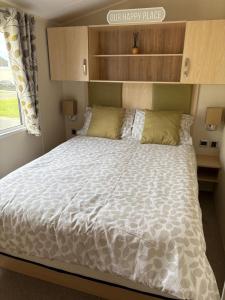 1 dormitorio con 1 cama con edredón blanco y ventana en Our Happy Place, en Kilkeel 4 fotos más