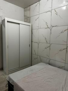 a bedroom with a bed and a white wall at Bela casa em Olinda in Olinda