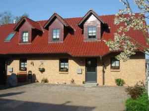 una gran casa de ladrillo con techo rojo en Holiday home in Waren with swimming pool, en Waren