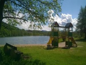 a park with a playground next to a lake at Lakefront Glamping w Pets in Herpelmont