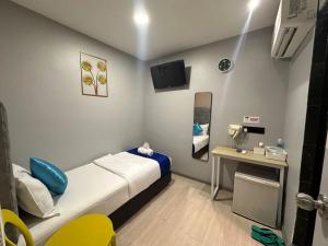a small room with a bed and a table at SS GREY INN Bb in Kuala Lumpur
