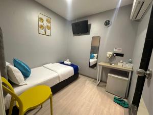 a small room with a bed and a table and chairs at SS GREY INN Bb in Kuala Lumpur