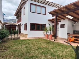 Casa blanca con techo de madera y patio en Exclusiva Casa BBQ Parking & Confort, en Villa de Leyva