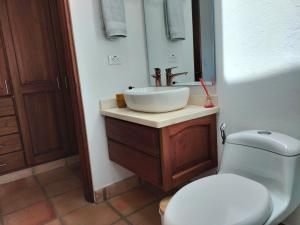 Un baño con un lavabo blanco y un inodoro. en Exclusiva Casa BBQ Parking & Confort, en Villa de Leyva 29 fotos más