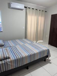 a bedroom with a bed with a striped blanket at Melhor custo beneficio in Governador Valadares +22 photos