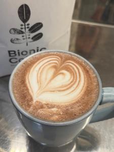 a cup of coffee with a heart drawn on it at The Kingfisher cabin in Tauranga