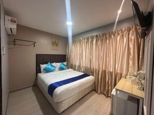 a bedroom with a large bed with blue pillows at SS GREY INN Bb in Kuala Lumpur +30 photos