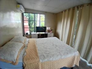 MexicanosにあるHades Metal Barのベッドとテレビと窓のある寝室