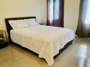 a bedroom with a large bed with a white comforter at Déjà Vu Sea View Apartments in Oyster Pond
