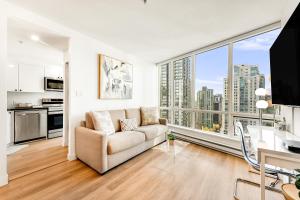バンクーバーにあるBest Location Downtown Chic Suitesのソファと大きな窓のあるリビングルーム