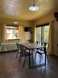 a dining room with a table and chairs and a bed at La huella in Río Ceballos +12 photos