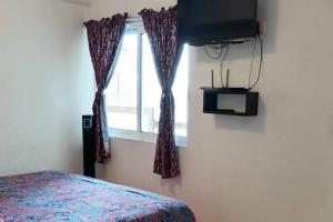 a bedroom with a bed and a window and a television at FRENTE AL MAR, centrico in Acapulco