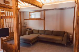a living room with a couch and a tv at Gyedong Hanok 125 in Seoul