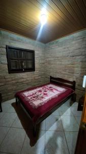 a bedroom with a red bed in a room at Sítio Canto do Monte in Rolante