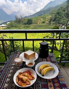 a table with plates of food and bananas on a balcony at Best View Homestay in Sa Pa +72 photos