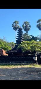 a building with palm trees in the background at Villa Koi in Keramas