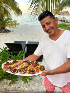 a man holding a plate of food on the beach at Ocean View PRIVATE BEACH in Cancún