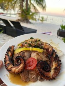 a white plate of food with a piece of meat at Ocean View PRIVATE BEACH in Cancún