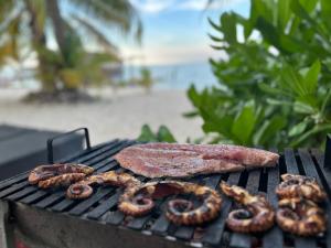a steak and sausage on a barbecue grill at Ocean View PRIVATE BEACH in Cancún